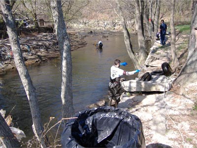 Workers from the CRMC and NBC clean up a section of the Woonasquatucket River