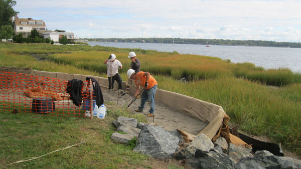 Workers fill the giant envelops with sand